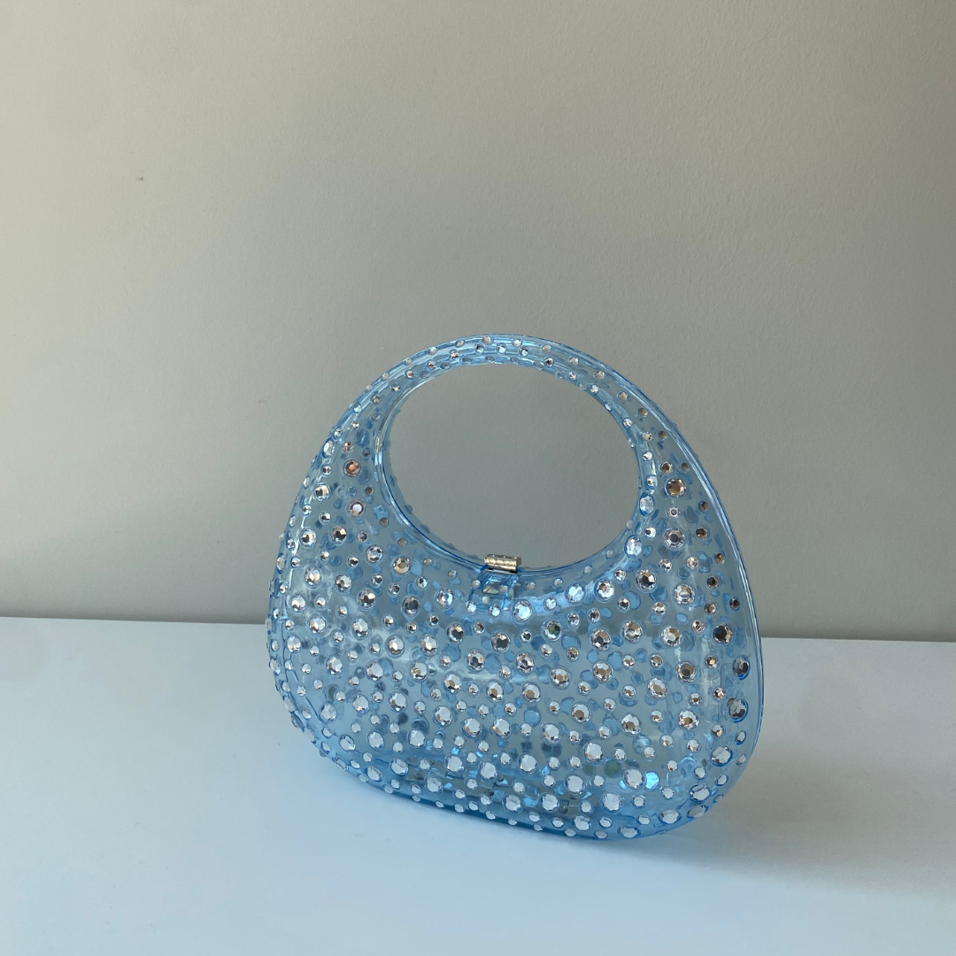 A sculptural mini made to shine. Top handle = your new favorite plus-one.