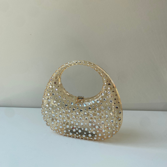 A sculptural mini made to shine. Top handle = your new favorite plus-one.