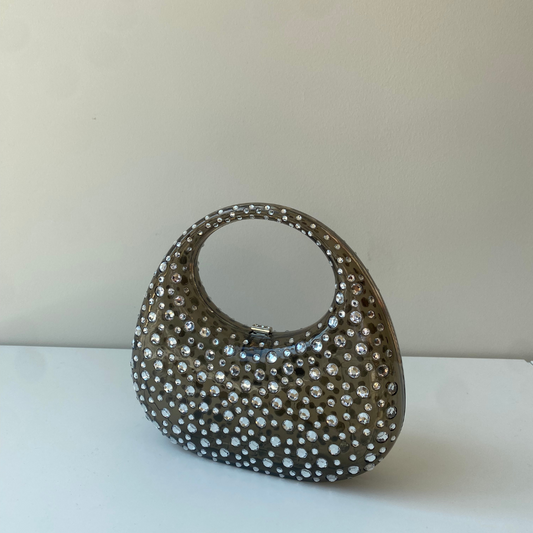 A sculptural mini made to shine. Top handle = your new favorite plus-one.